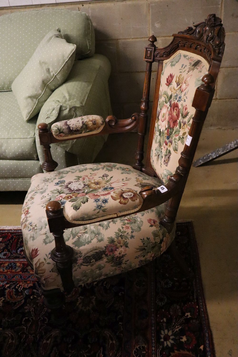 A late Victorian carved walnut upholstered open armchair